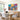 Colorful tropical sea and sun folk art canvas artwork creating a lively cheerful atmosphere mounted above a modern wooden dining table.