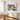 Vibrant pink and purple pop art floral canvas artwork creating a fun joyful atmosphere mounted above a contemporary wooden dining room table.