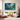 Hand painted deep blue abstract floral oil painting with pink wildflower splatters hanging over a grey sofa in a modern living room.