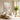 Large textured pastel impressionist canvas wall art displaying soft pink and yellow impasto brushstrokes in a minimalist living room setup.