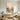 Tranquil sunset abstract landscape painting with rich palette knife textures hanging above an upholstered bed frame in a soothing bedroom interior.