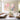Hand painted pink cherry blossom canvas painting set of 2 with thick impasto petal texture hanging above a white linen sofa in a bright living room.