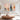 Hand painted blush pink and terracotta abstract canvas painting set of 2 with gold foil flecks hanging over a grey sofa in a modern living room.
