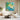 Hand-painted vibrant green garden abstract canvas framed above beige sofa in modern living room, bringing natural freshness to home decor.