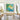 Large hand-painted ocean and floral artwork hung over fireplace in contemporary living room, adding refreshing bohemian charm to the space.