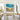 Textured abstract ocean waves and colorful beach flowers canvas painting mounted in a minimalist lounge room for stylish focal point.
