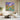 Textured abstract galaxy and bright flower canvas painting mounted in contemporary lounge, creating a captivating artistic focal point.