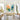 Framed 3D textured abstract flower oil painting bringing joyful sunny energy above a light wood console table in a contemporary living room.