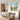 Vibrant blue and coral pink wildflower canvas painting creating a cheerful light-filled atmosphere mounted above a wooden dining room table.