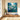 Square hand painted jewel tone flower canvas artwork displaying rich knife textures forming a striking focal view along a hallway wall.