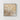 Framed floral artwork with white and gold flowers on a beige background