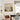 Square romantic seaside sunset canvas art hung on a white dining room wall above a dark wooden dining table with modern chairs.