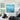 Large turquoise blue square abstract canvas painting with 3D impasto texture mounted on a white wall in a high-ceiling modern loft.