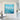 Oversized ocean waves abstract canvas wall art hanging in a bright open-concept dining area next to a dark wood table.