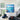 Oversized turquoise ocean horizon canvas art with impasto texture displayed on a high-ceiling living room wall next to a black metal staircase.